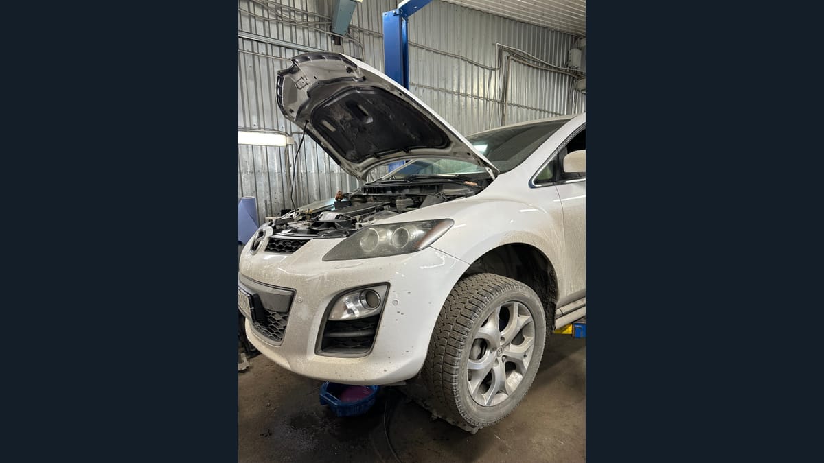 Осмотр автомобиля с открытым капотом в сервисе